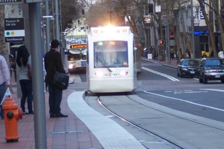 LRT train on Portland's 5th Ave. transit mall swings to the curbside station to pick up waiting passengers. Photo: L. Henry.