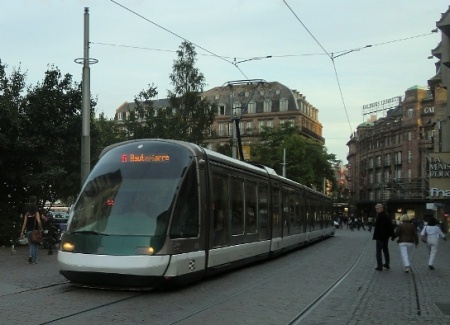 As evening approaches, a tram glides through Strasbourg's Place Kléber as pedestrians stroll along the other track. Photo: Franz Roski.