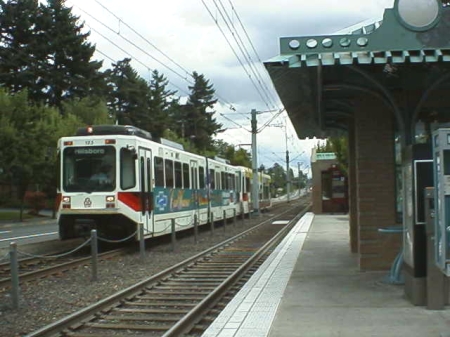 In the photo above a train on the opposite track passes the East 102nd Ave. station. Even with a platform width of only 10-12 feet, LRT stations have sufficient space for TVMs (ticket vending machines), a shelter, waiting bench, and other amenities.