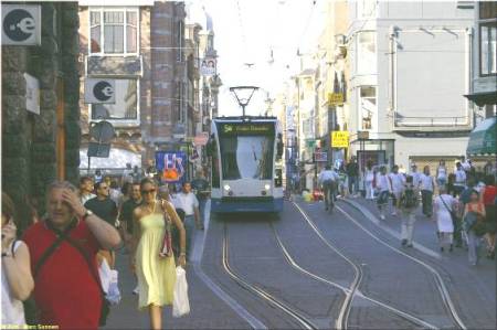 Another photo showing crowds of pedestrians, an approaching tram, and a clearview of a transition from double-track to interlaced track. (Photo: Marc Sonnen.)