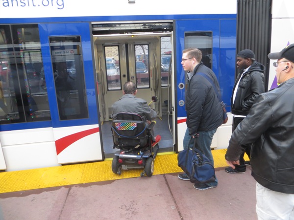 Passenger in wheelchair boards train at downtown station. Photo: L. Henry.